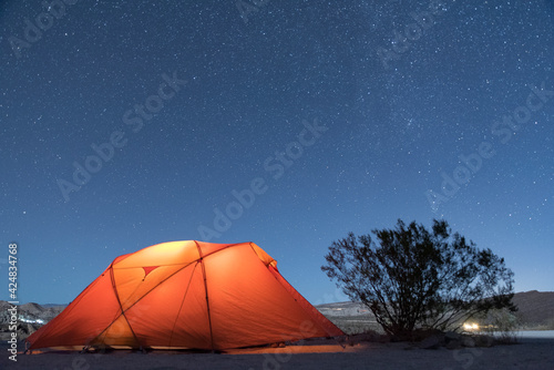 Orange tent at night in desert landscape