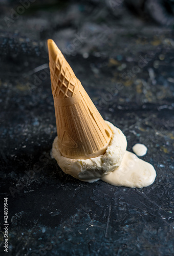 Fallen ice cream upside down on dark concrete