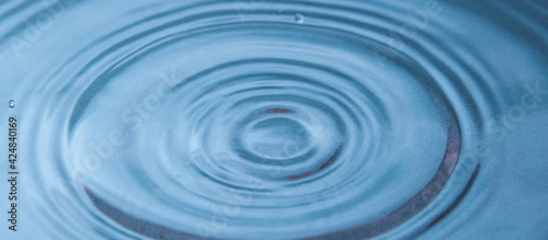Circles on the blue surface of the water close-up
