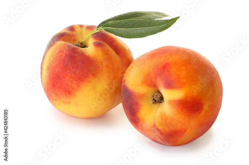 Two peaches with leaves isolated on white background