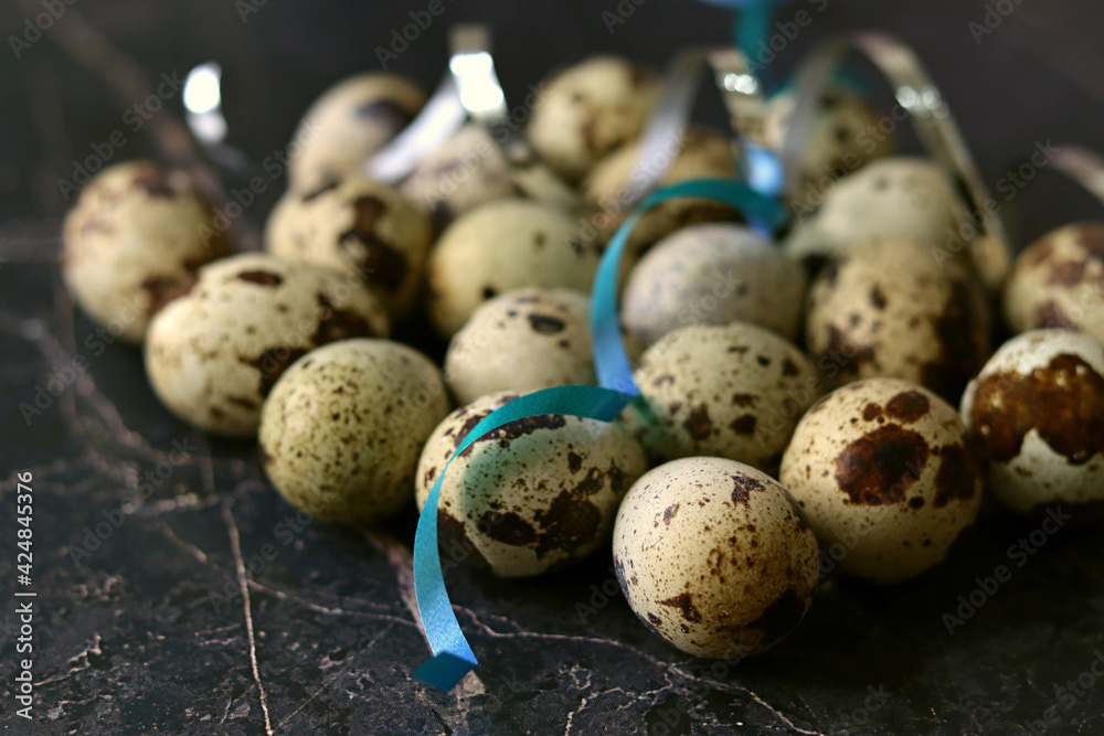 Obraz premium Close-up view of fresh raw quail eggs over blue concrete stone or marble backround. Top view