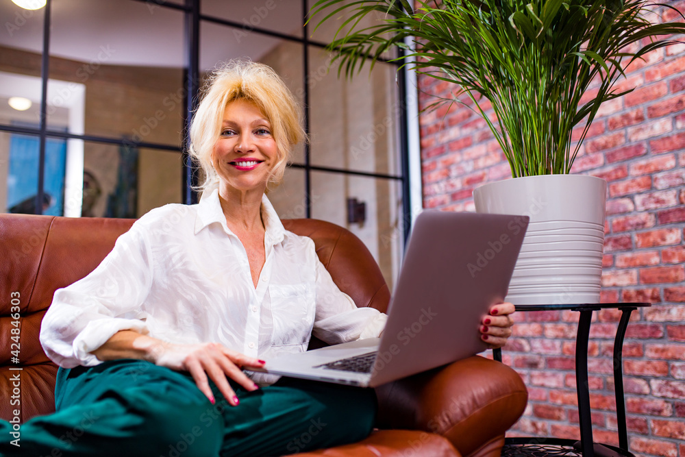glamourous middle-aged designer architect woman completing an apartment project talking by video chat with client at evening dead line glamourous middle-aged designer architect woman completing an apartment project talking by video chat with client at evening dead line