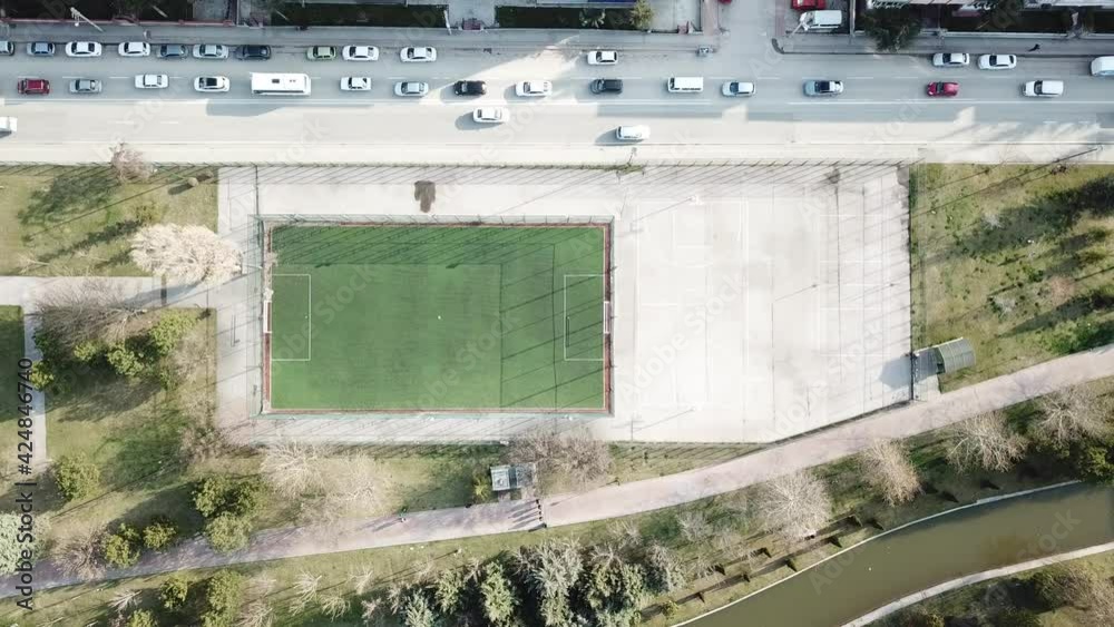 Aerial view of empty football field and basketball court at the city center. Vehicles, buildings and river can be seen Aerial view of empty football field and basketball court at the city center. Vehicles, buildings and river can be seen