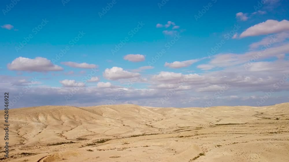 Flight over hills in desert Negev with fluffy clouds Flight over hills in desert Negev with fluffy clouds