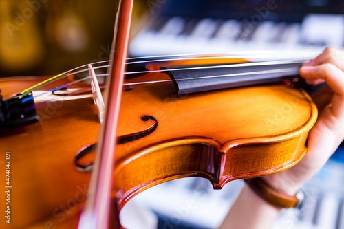 Violinist hands playing violin orchestra musical instrument closeup indoor