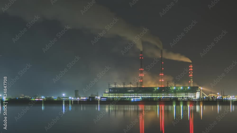 Time lapse of coal power plant high pipes with black smoke moving fast polluting atmosphere at night with reflections of it in lake water. Time lapse of coal power plant high pipes with black smoke moving fast polluting atmosphere at night with reflections of it in lake water.