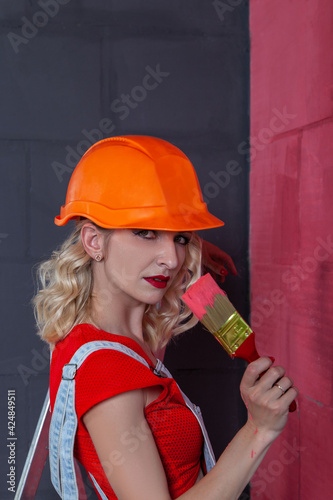 Woman paints the walls, makes repairs