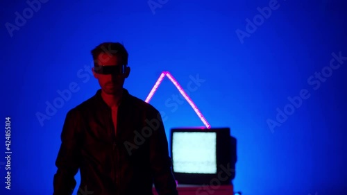 Man in futuristic glasses looks towards the camera.   Blue light, neon, LED, cyberpunk. photo