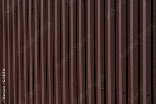 brown corrugated fence, the building is sheathed with corrugated board