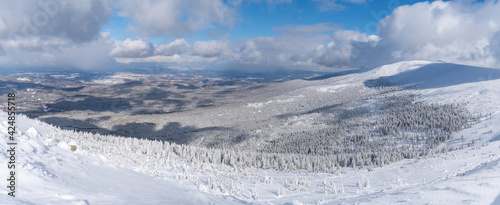 Winter mountain landscape, Poland, Panorama of the Giant Mountains in sunny winter day, from Biała Dolina in Szklarska Poreba on Szrenica and Sniezne Kotly, blue sky, white and dark clouds. Snow cover © Marcin