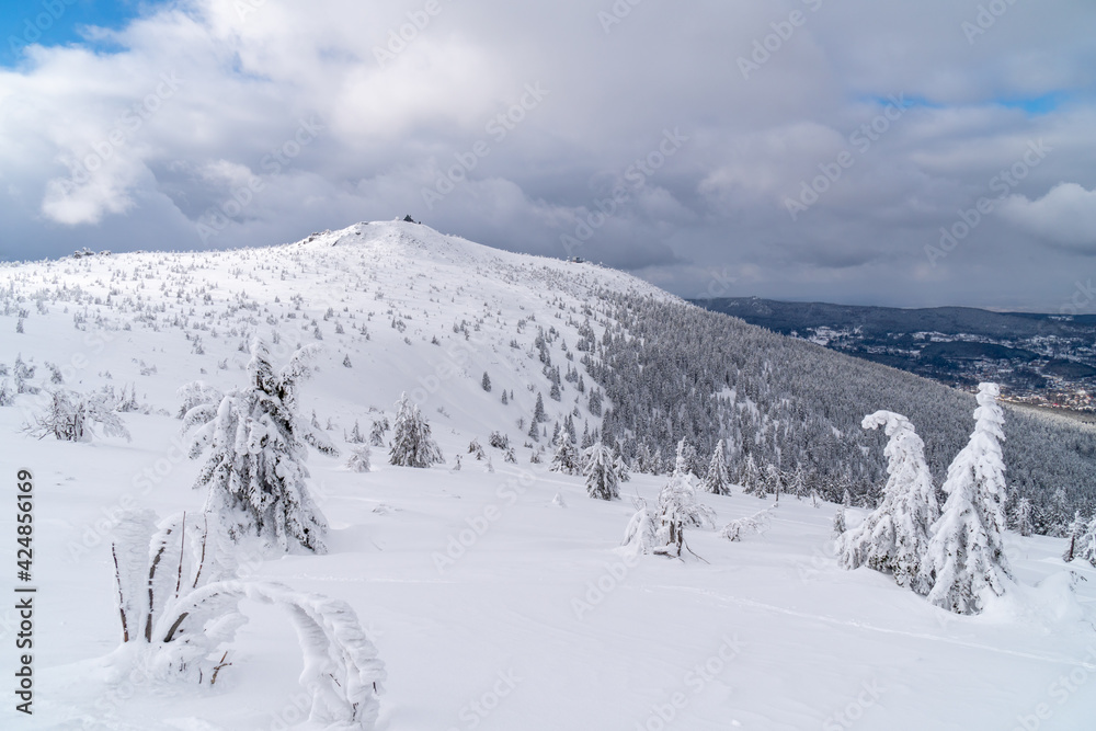 Winter mountain landscape, Poland, Panorama of the Giant Mountains in sunny winter day, from Biała Dolina in Szklarska Poreba on Szrenica and Sniezne Kotly, blue sky, white and dark clouds. Snow cover
