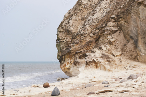 Small waves rolling under the limestone cliff at Bulbjerg in Denmark photo