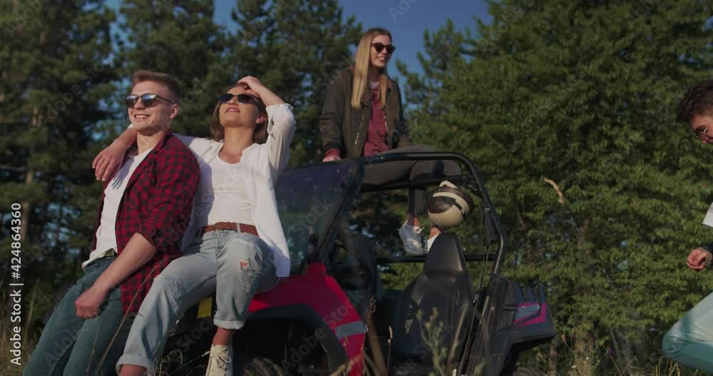 Group of young hipster couple enjoying morning sun on off road car and having fun Group of young hipster couple enjoying morning sun on off road car and having fun