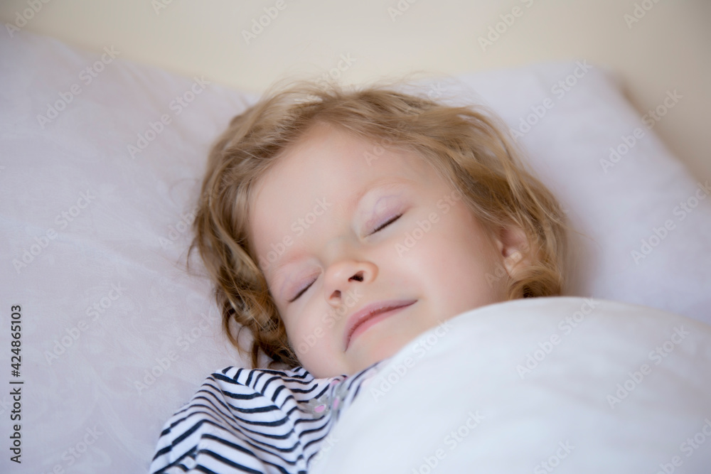 little girl sleeps sweetly on a white pillow on a light background. The concept of health. Close up little girl sleeps sweetly on a white pillow on a light background. The concept of health. Close up