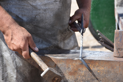 Blacksmith forged ironsmith. traditional hammer beating. Medieval blacksmith. Horseshoe workspace made with the medieval blacksmith method.