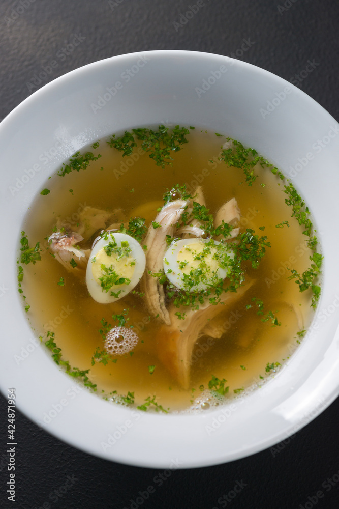 Freshly cooked chicken broth, bullion, soup with eggs and herbs Freshly cooked chicken broth, bullion, soup with eggs and herbs