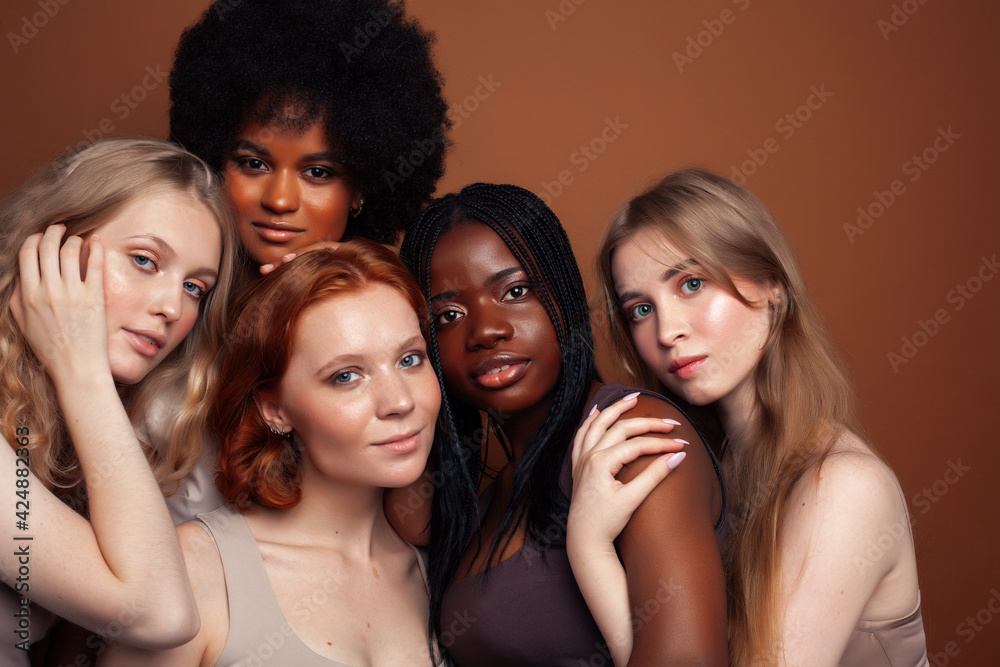 Fototapeta premium young pretty caucasian, afro, scandinavian woman posing cheerful together on brown background, lifestyle diverse nationality people concept