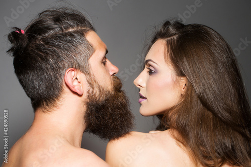 Young naked couple portrait of sexy woman and handsome bearded man.