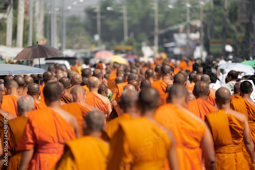 a group of monk on pilgrimage walk on the street at noon time, Thailand.