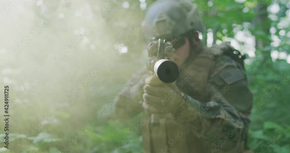 Silhouette of the Fully Equipped Soldier Moving Through Smokey Forest. Military action Silhouette of the Fully Equipped Soldier Moving Through Smokey Forest. Military action