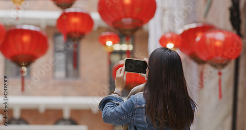 Woman use of mobile phone to take photo of the chinese lantern