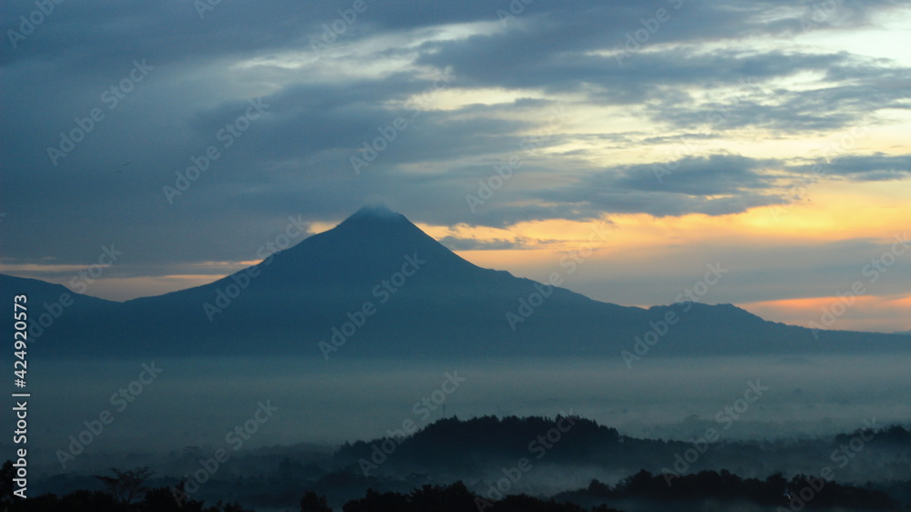 Sunrise facing The Merbabu Mountain. In Magelang, Indonesia. The sky is a bit cloudy at that morning