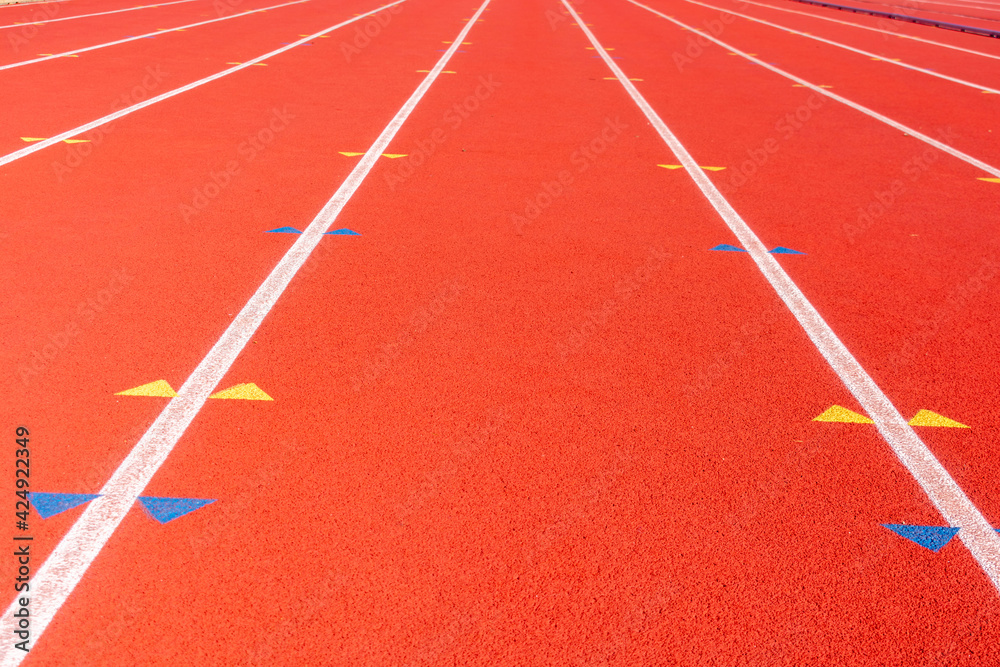 Track and field race course lanes with yellow and blue arrows for hurdles placement during hurdle races.