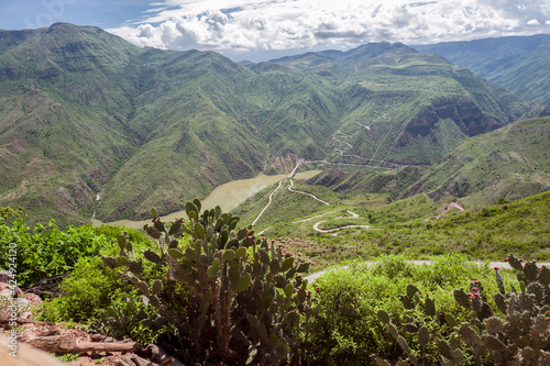 High altitude panoramic view of the green Andean mountains and Sogamoso river, a curved road to Zapatoca, a touristic town in the Santander Department in northeastern Colombia, South America. photo