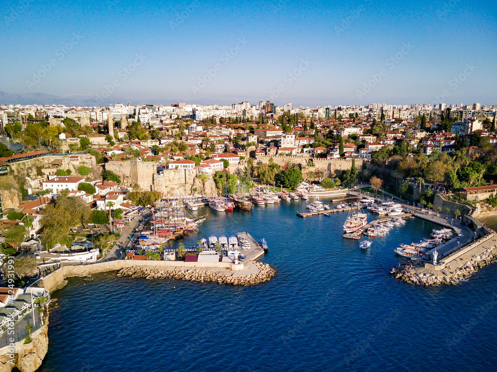 Aerial photograph of Antalya bay in Antalya city from high point of drone fly on sunny day in Turkey. Amazing aerial cityscape view from birds fly altitude on beautiful town and sea full of yahts