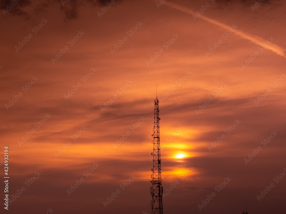 Communication GSM and internet antenna silhouette with dramatic sunset sky in background Communication GSM and internet antenna silhouette with dramatic sunset sky in background