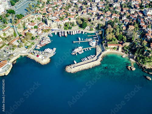 Aerial photograph of Antalya bay in Antalya city from high point of drone fly on sunny day in Turkey. Amazing aerial cityscape view from birds fly altitude on beautiful town and sea full of yahts