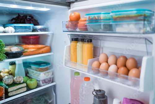 open fridge door with full of food and ingredient inside photo