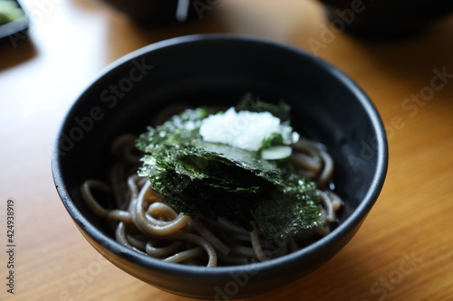 Close-up of Crispy dried seaweed, Nori chips piece of roasted seaweed sheet with noodle in a bowl on wooden table. Healthy food concept, flat lay roasted seaweed