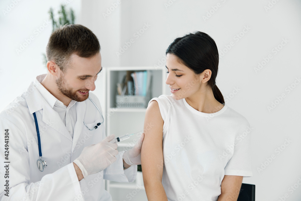 doctor giving a shot to a woman in the shoulder vaccination epidemic hospital doctor giving a shot to a woman in the shoulder vaccination epidemic hospital