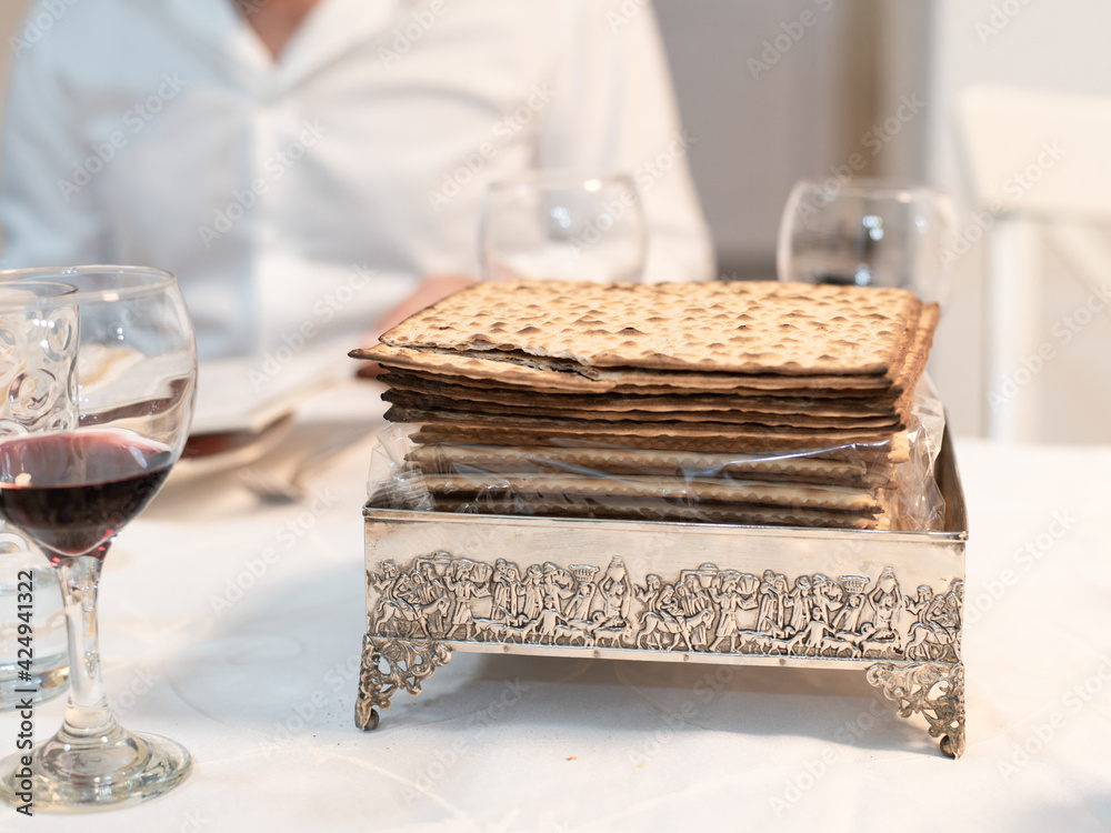 Matzo- thin unleavened flatbread, national Jewish food served on  table on special plate. Matzo traditionally prepared for Passover.  Spring Holiday. Fasting time. Close-up.
