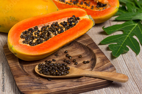 Fresh papaya cut in half on a wooden table