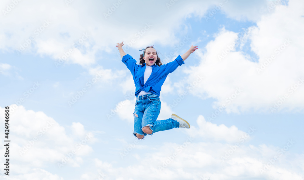 cheerful child jump in casual denim apparel outdoor, happiness