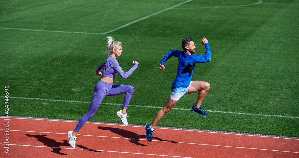 Fototapeta premium athletic couple of sprinters run on running track at stadium, success