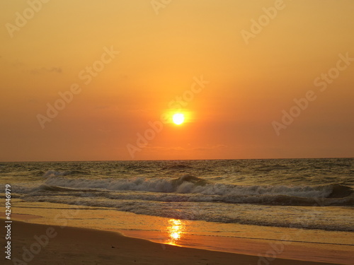 The sun setting on the horizon and the orange sky (Morondava Beach, Madagascar)