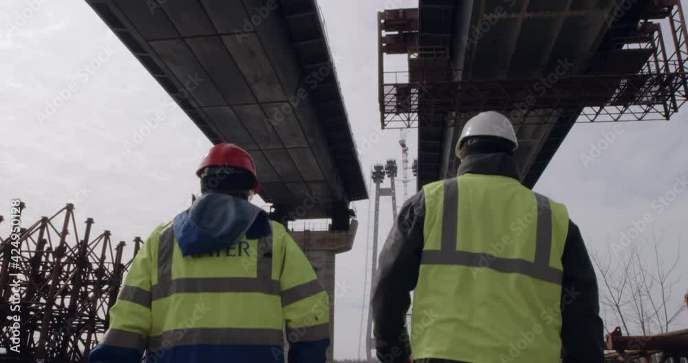 Unrecognizable men inspecting bridge construction site