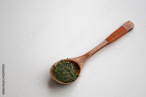 木製のスプーンにのった緑茶の茶葉