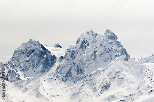 Snowy Mount Ushba and Schelda on cloudy background in winter  Greater Caucasus, Russia © Anna