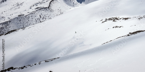 Backcountry skier riding down the Mt Cheget slope in Kabardino-Balkaria, Russia