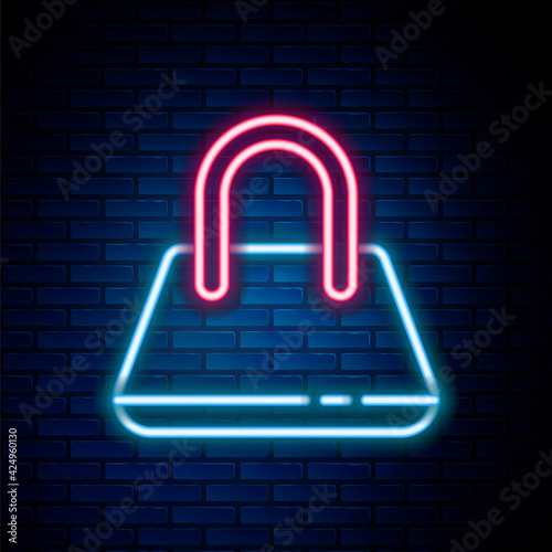 Glowing neon line Handbag icon isolated on brick wall background. Female handbag sign. Glamour casual baggage symbol. Colorful outline concept. Vector