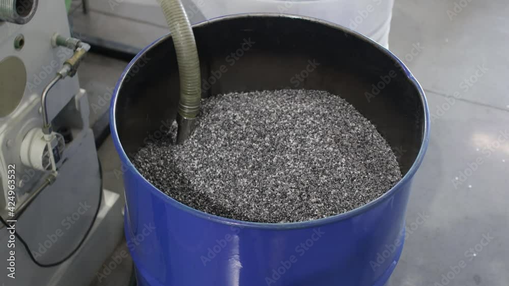 Factory worker fills a bag with polypropylene granules. barrel PP Pet Chips Semi Dull, PET chips recycle, PET polyester chips Factory worker fills a bag with polypropylene granules. barrel PP Pet Chips Semi Dull, PET chips recycle, PET polyester chips
