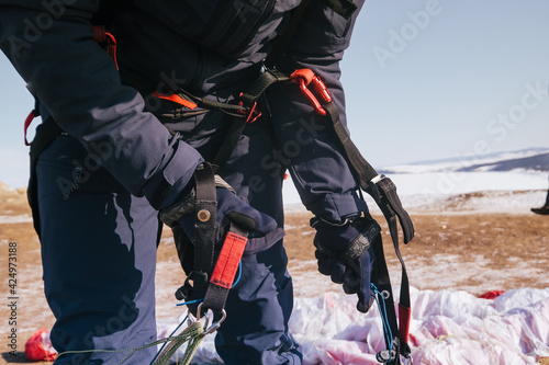 Tourist paraglider climbing mountain above the winter lake Baikal