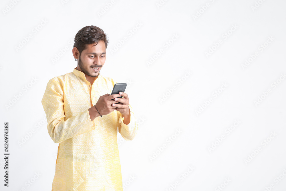 Young indian man in tradition wear and using smartphone on white background. Young indian man in tradition wear and using smartphone on white background.