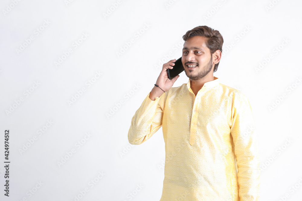Young indian man in tradition wear and talking on smartphone. Young indian man in tradition wear and talking on smartphone.