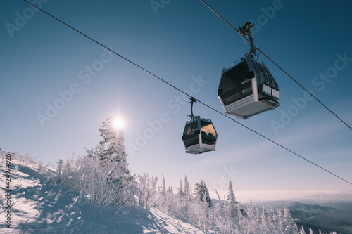 gondola ski lift in mountain ski resort, winter day, snowy spruce forest