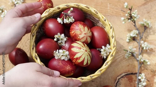 Basket with Easter cake and red eggs on rustic wooden table. Natural ecological staining with food coloring. Top view.
